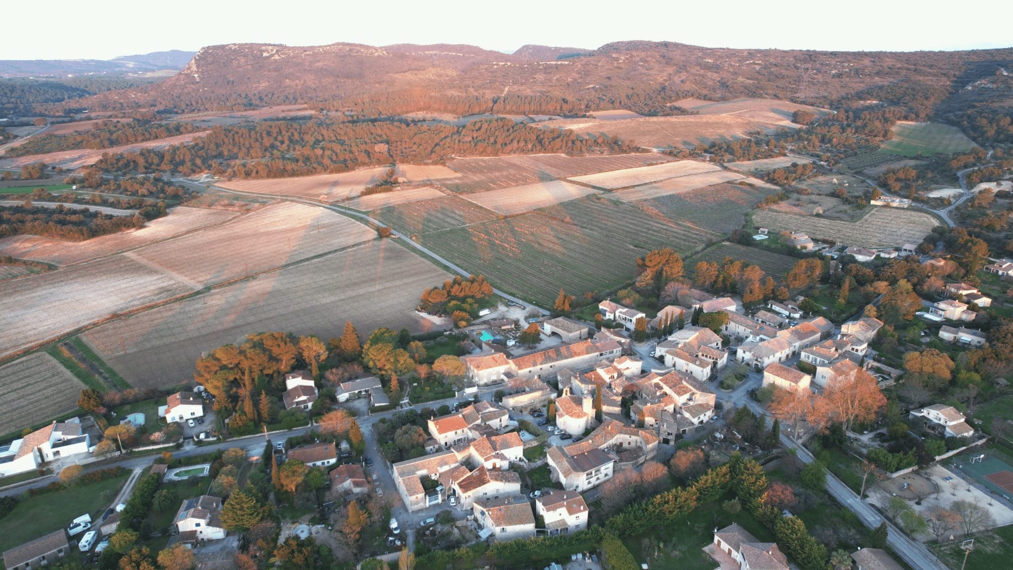 Vue du village de Garrigues avec en son centre le Château Roumanières surplombé par la colline de la Pene